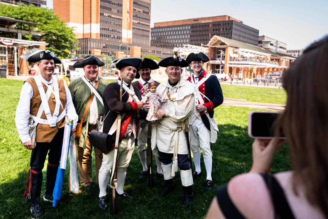 Reenactors pose for a photo with the American Girl doll Felicity Merriman, who represents the American Revolutionary War period, near Independence Hall following the cancellation of the Salute to Independence Semiquincentennial Parade due to heat in Philadelphia, Pa., on July 3, 2026. Philadelphia is celebrating the 250th anniversary of the United States of America. (Al Drago/Getty Images)