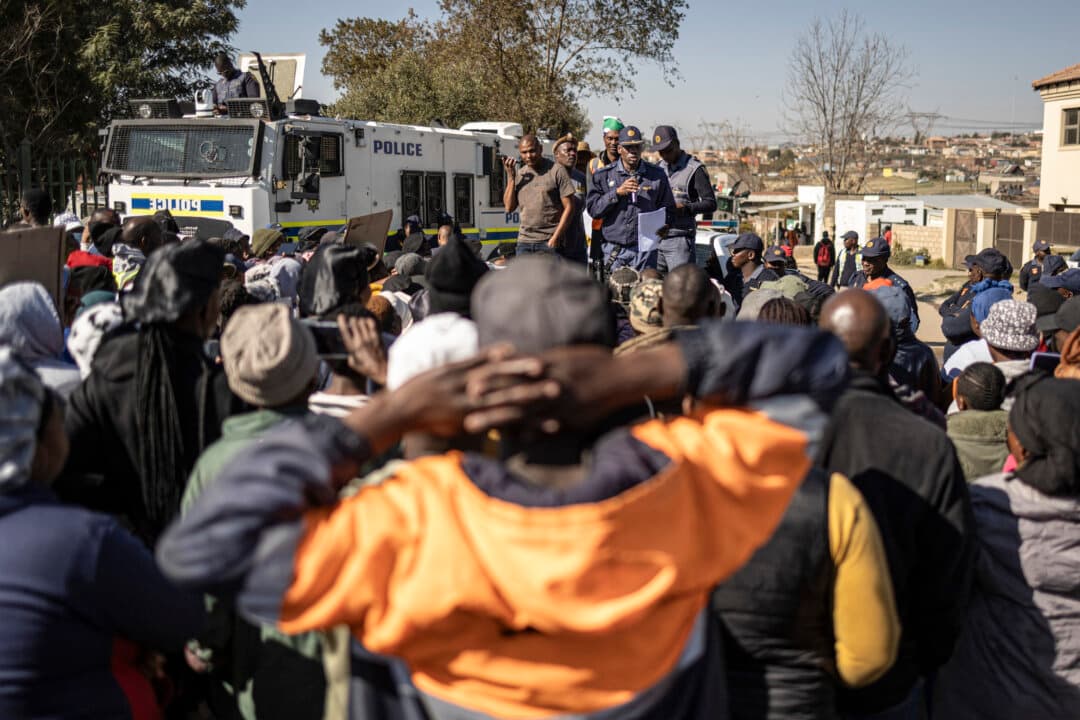 Community members gather outside the Olievenhoutbosch police station in Centurion, Gauteng, South Africa, on July 4, 2026. (Emmanuel Croset/AFP via Getty Images)