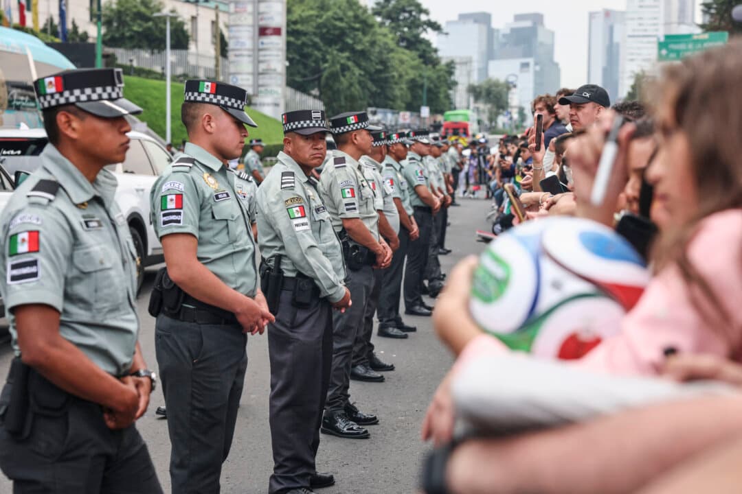 Members of the national guard stand between fans and the the bus that will transport England's national football team players from the Marriott Hotel to their July 5 FIFA World Cup 2026 match against Mexico, in Mexico City, on July 4, 2026. (Claudia Rosel/AFP via Getty Images)