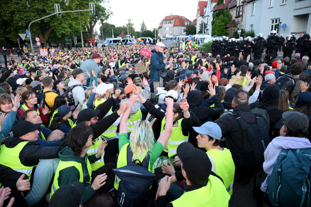Police in the background watch as demonstrators gather for a sit-in to block the access road at Gothaer Platz, Germany, on early July 4, 2026, where the party congress of Alternative for Germany will be held from July 4–5. (Ralf Hirschberger/AFP via Getty Images)