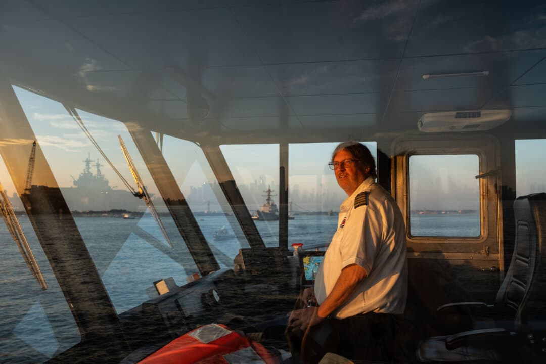 A ferry operator sails towards the USS Kearsarge ahead of the International Naval Review 250 in New York City on July 4, 2026. (Samira Bouaou/The Epoch Times)