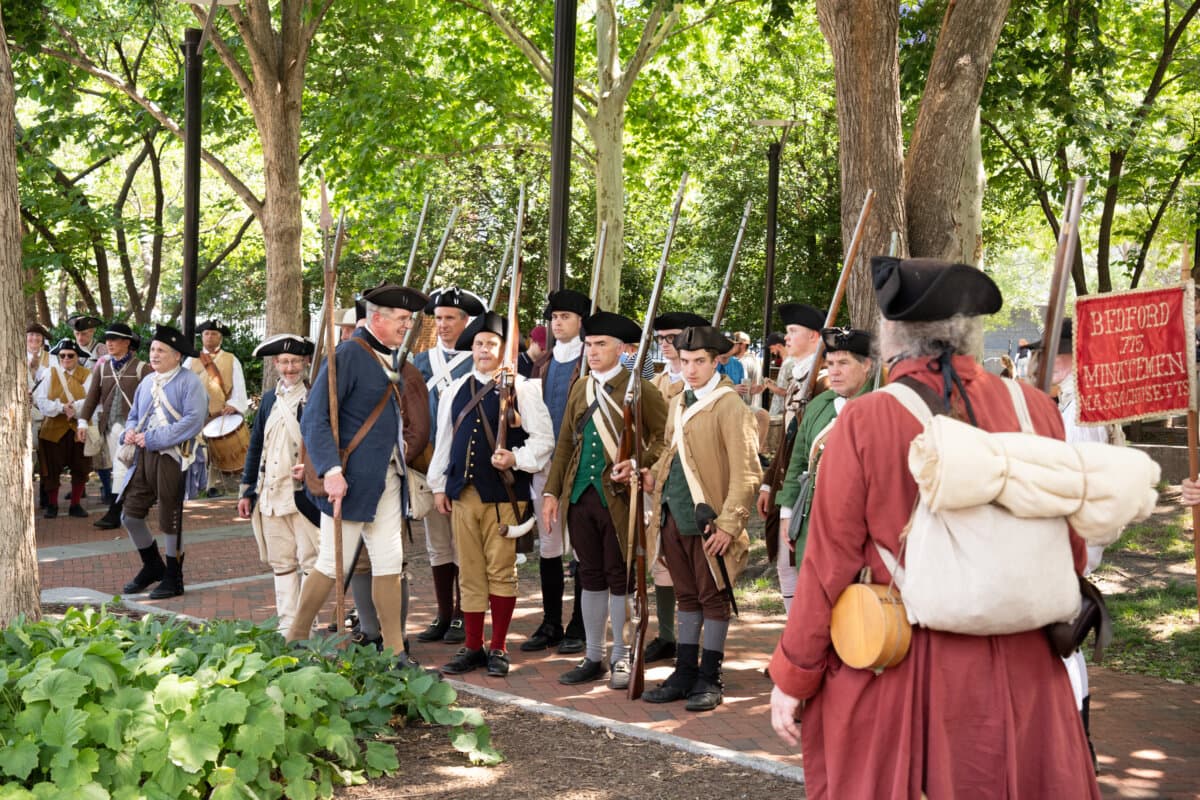 Thousands of costumed performers take a break in the shade around Philadelphia Independence Mall, as they celebrate America's 250th anniversary, on July 3, 2026. (Larry Dye/The Epoch Times)