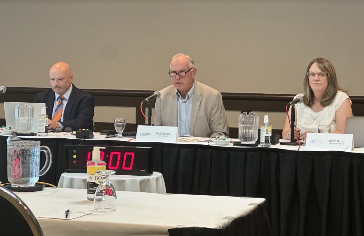 Commissioner Rory Francis (C) speaks at a public hearing of the Review of the Island Regulatory and Appeals Commission in Charlottetown on July 6, 2026. Also appearing on the panel are Kelly VanBuskirk (L), legal counsel for the commission, and Dawn Binns, executive director of the commission. (Omid Ghoreishi/The Epoch Times)