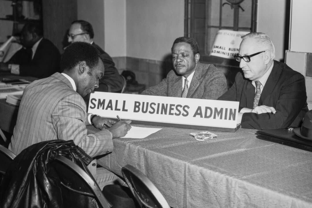 A businessman (L) interested in doing business with the federal government registers his company's name, address, and specialty with representatives of the Small Business Administration in Harlem, New York City, circa 1960. Limited liability corporations, introduced in the United States in the 19th century, made entrepreneurship more accessible by allowing ordinary people to start businesses. (Archive Photos/Getty Images)