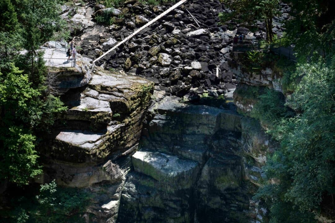 Hikers look at the dry riverbed of the Doubs river at the Saut du Doubs waterfall in Villers-le-Lac, France, on July 9, 2026. (Sebastien Bozon/AFP via Getty Images)