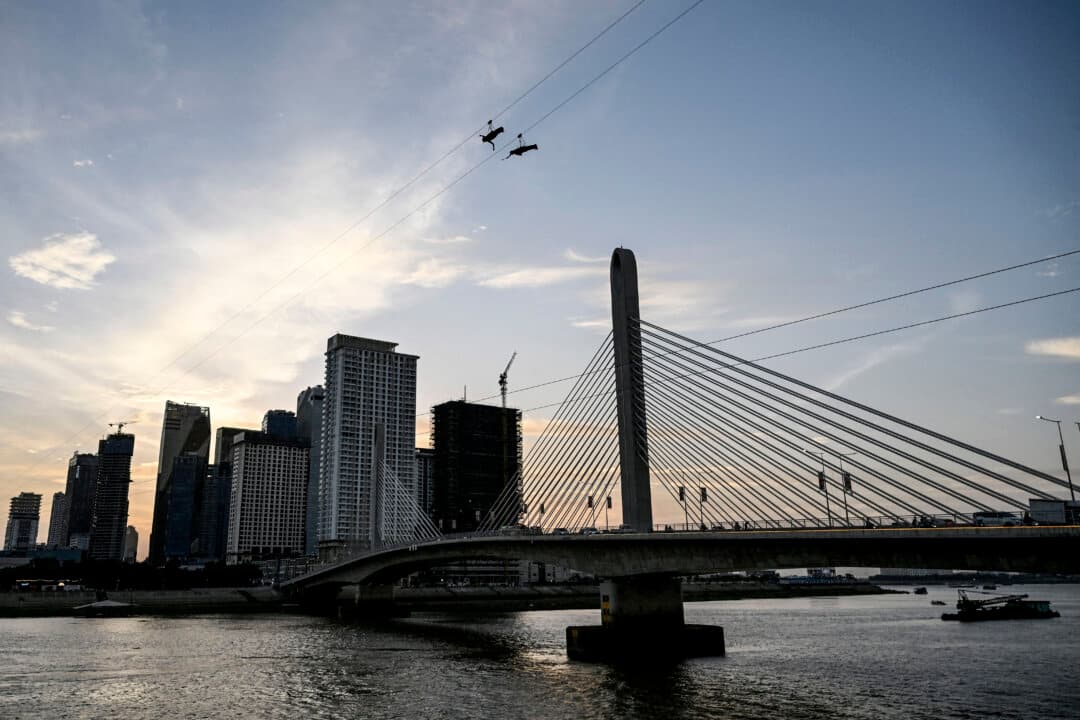 A couple ride the Mekong Zipline, which connects the islands Koh Pich and Norea across the Bassac River, in Phnom Penh, Cambodia, on July 9, 2026. (Tang Chhin Sothy/AFP via Getty Images)