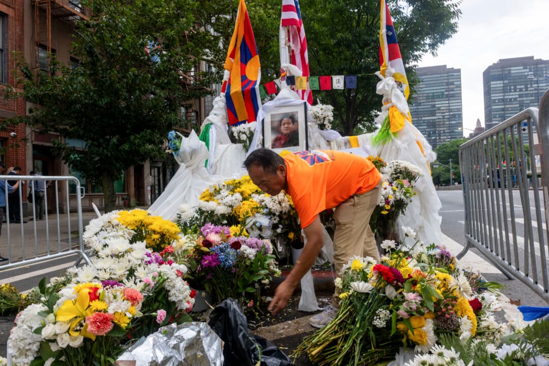 Tibetan activists tend to a memorial as they hold a protest in front of the United Nations (U.N.) on the one-week anniversary of the death of 52-year-old Tibetan Lobga Rangzenan, who died in an apparent act of self-immolation outside the U.N. headquarters in New York City on July 9, 2026. The activists blocked an entrance to the U.N. and numerous members chained themselves to the front gate. (Spencer Platt/Getty Images)