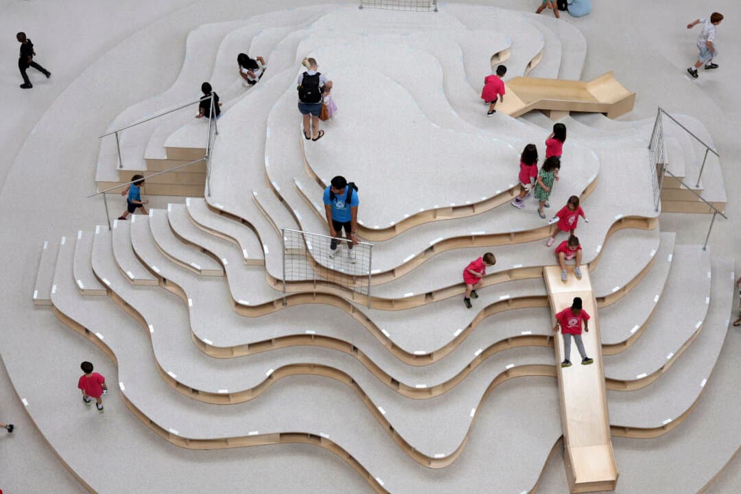 Children enjoy the Hill portion of the National Building Museum’s newest installation, The Playground, in Washington on July 9, 2026. Designed by the New York studio Snarkitecture, the museum’s largest indoor installation features nine play zones built from construction materials such as plywood and scaffolding. (Alex Wong/Getty Images)