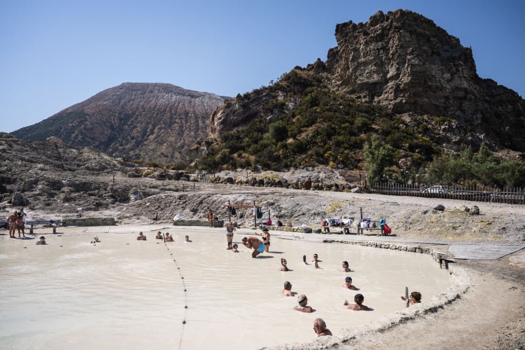 People immerse themselves in the natural thermal mud pool in Vulcano Island, part of the Eolian Archipelago, off Sicily, Italy, on July 10, 2026. (Marco Bertorello/AFP via Getty Images)