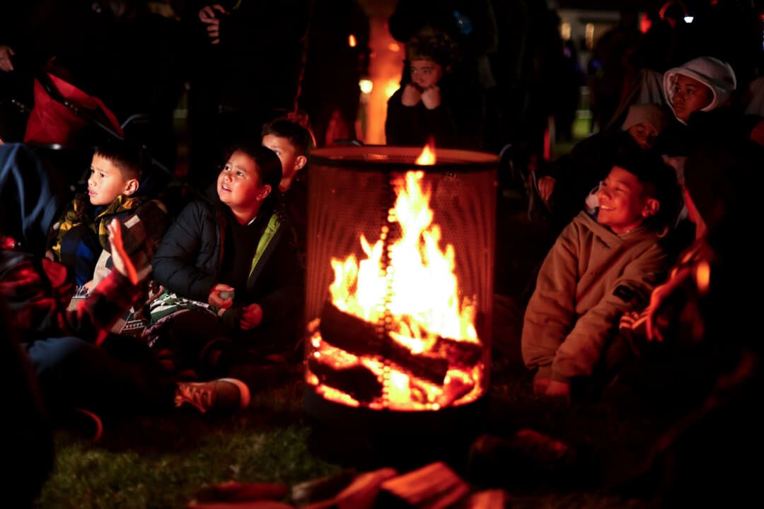 Families gather around a fire during the Matariki Dawn Ceremony (Hautapu) at Takaparawhau (Bastion Point) in Auckland, New Zealand, on July 10, 2026. Matariki, the Maori New Year, marks the reappearance of the Matariki (Pleiades) star cluster and is a time to remember those who have passed, celebrate the present, and look ahead to the year ahead. (Phil Walter/Getty Images)