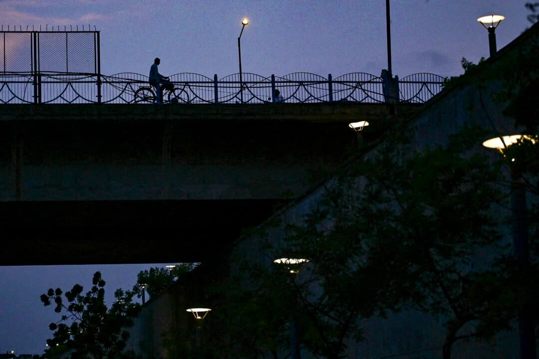 A cyclist travels over a bridge on the Sabarmati River in Ahmedabad, India, on July 11, 2026. (Shammi Mehra/AFP via Getty Images)