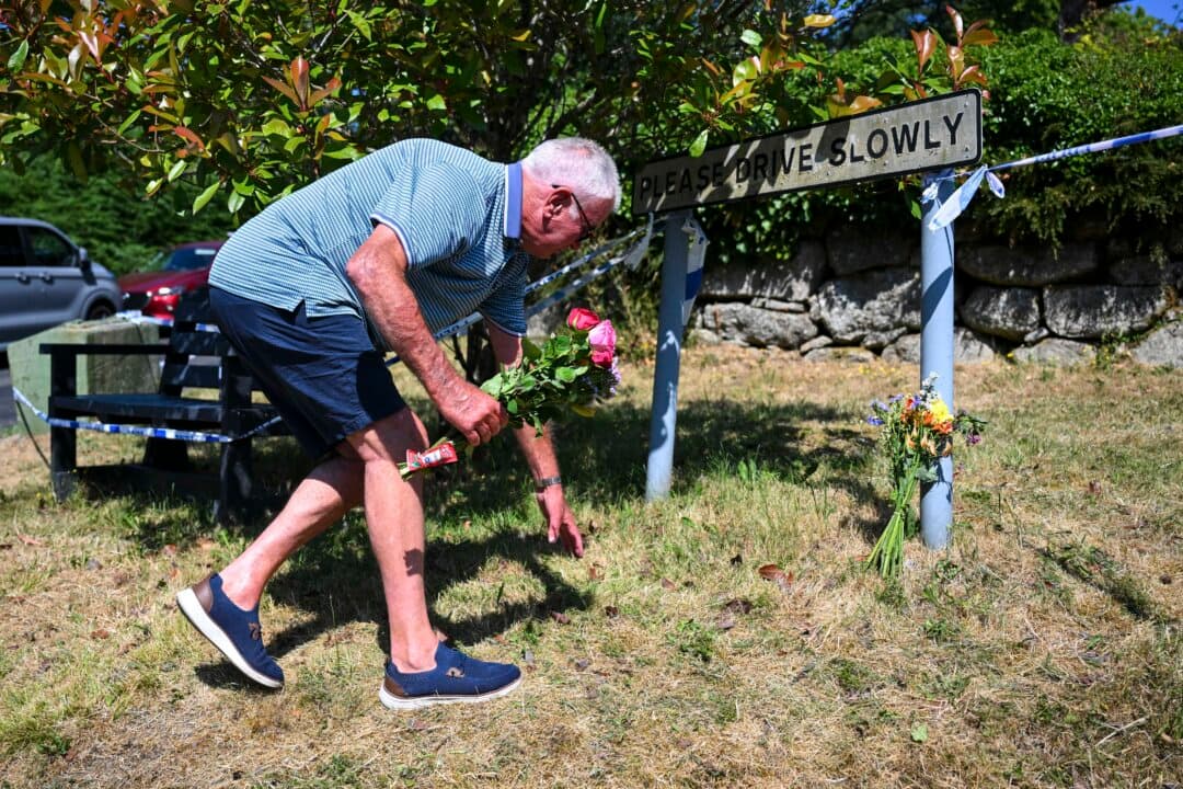 A man lays flowers outside the house of Ann Widdecombe in Haytor, Dartmoor, England, on July 11, 2026 . The former Conservative minister and member of parliament for Maidstone and The Weald was found dead at her home on Dartmoor on the morning of July 9 having sustained serious head injuries. (Finnbarr Webster/Getty Images)