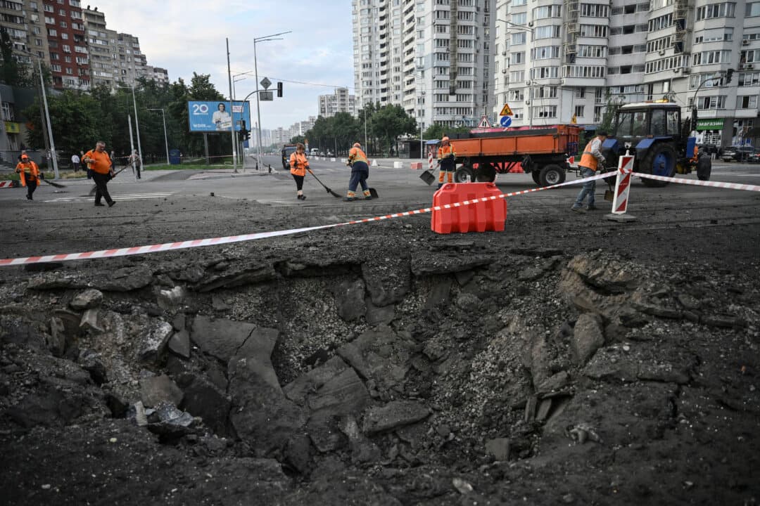 Communal workers clean around a crater from Russian missile strikes on the Ukrainian capital of Kyiv, on July 11, 2026. (Genya Savilov/AFP via Getty Images)