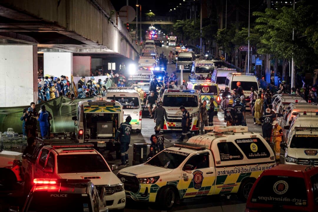 An ambulance is parked outside a bar after a massive fire broke out in Bangkok early on July 13, 2026. At least 27 people were killed. (Chanakarn Laosarakham/AFP via Getty Images)