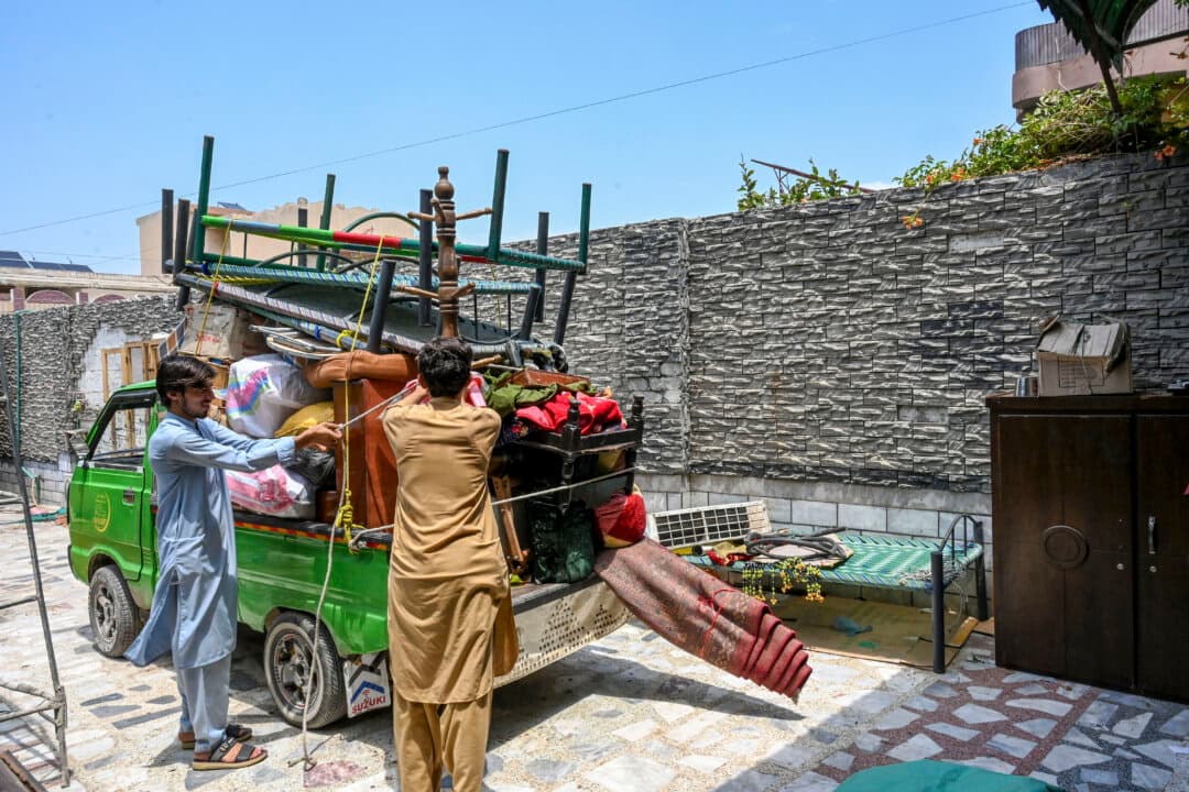 Afghan refugees load their belongings onto a truck in Peshawar, Pakistan, on July 13, 2026, as they prepare to depart for Afghanistan. (Abdul Majeed/AFP via Getty Images)