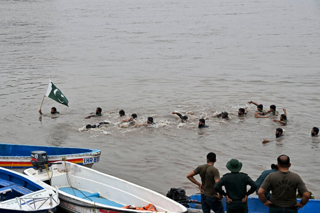 Relief personnel conduct a flood rescue drill during monsoon season as a precautionary measure at the Ravi river in Lahore, Pakistan, on July 13, 2026. (Arif Ali/AFP via Getty Images)
