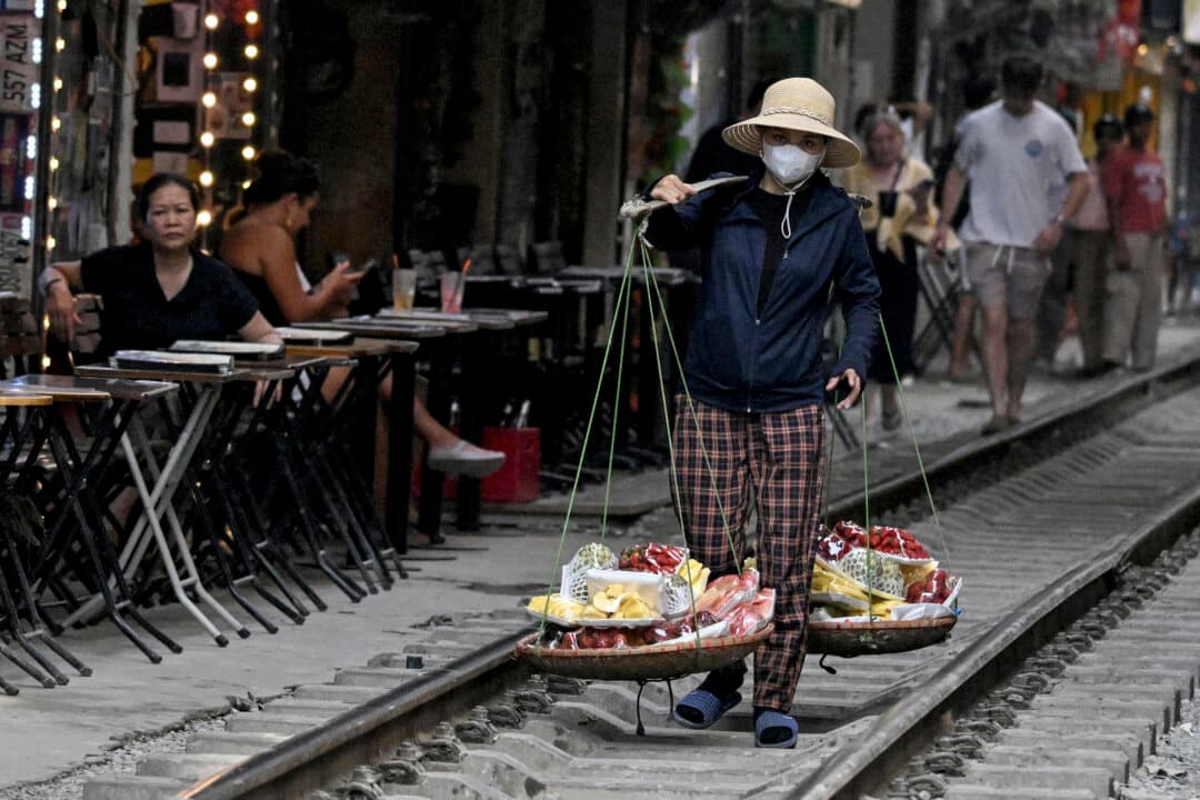 A street vendor walks along the railway tracks in Hanoi, Vietnam, on July 13, 2026. (Nhac Nguyen/AFP via Getty Images)