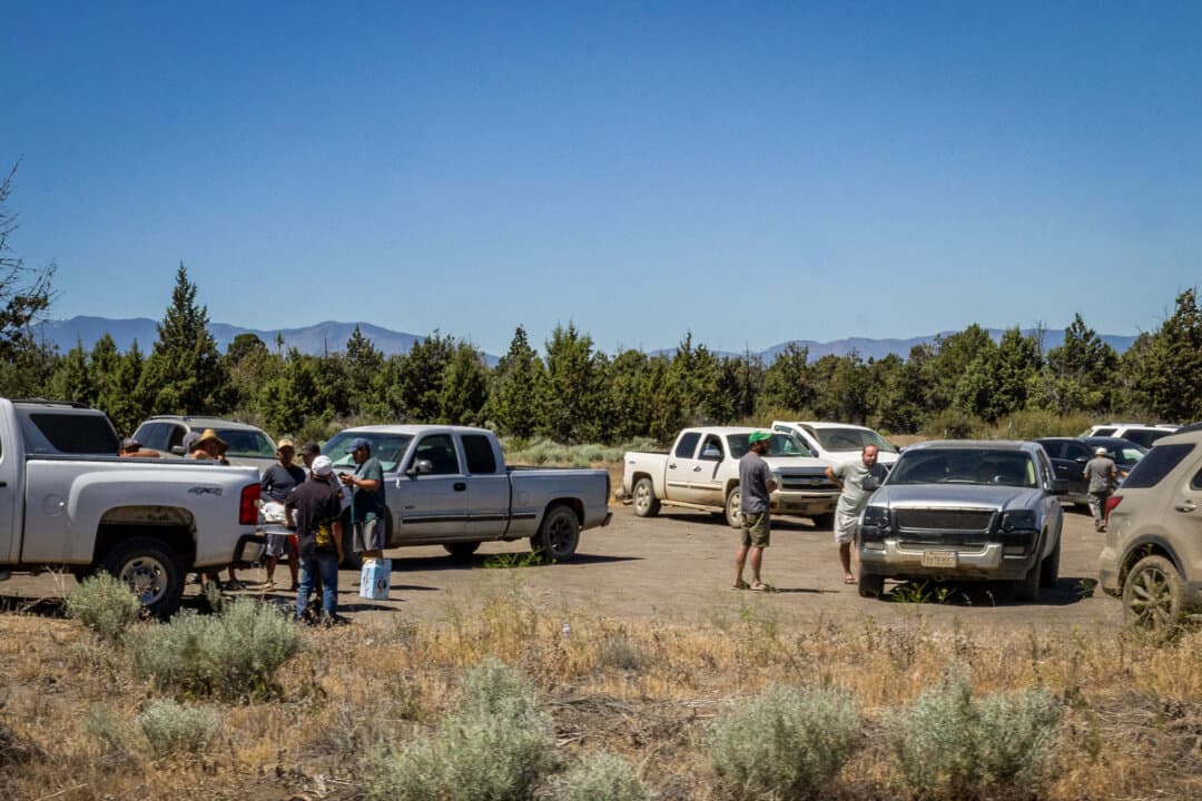Men wait for police officers to leave from their investigations of illegal marijuana farms outside of Montague, Calif., on June 4, 2026. Spotters are sometimes armed with AK-47s or rifles, nearby residents say. (John Fredricks/The Epoch Times)