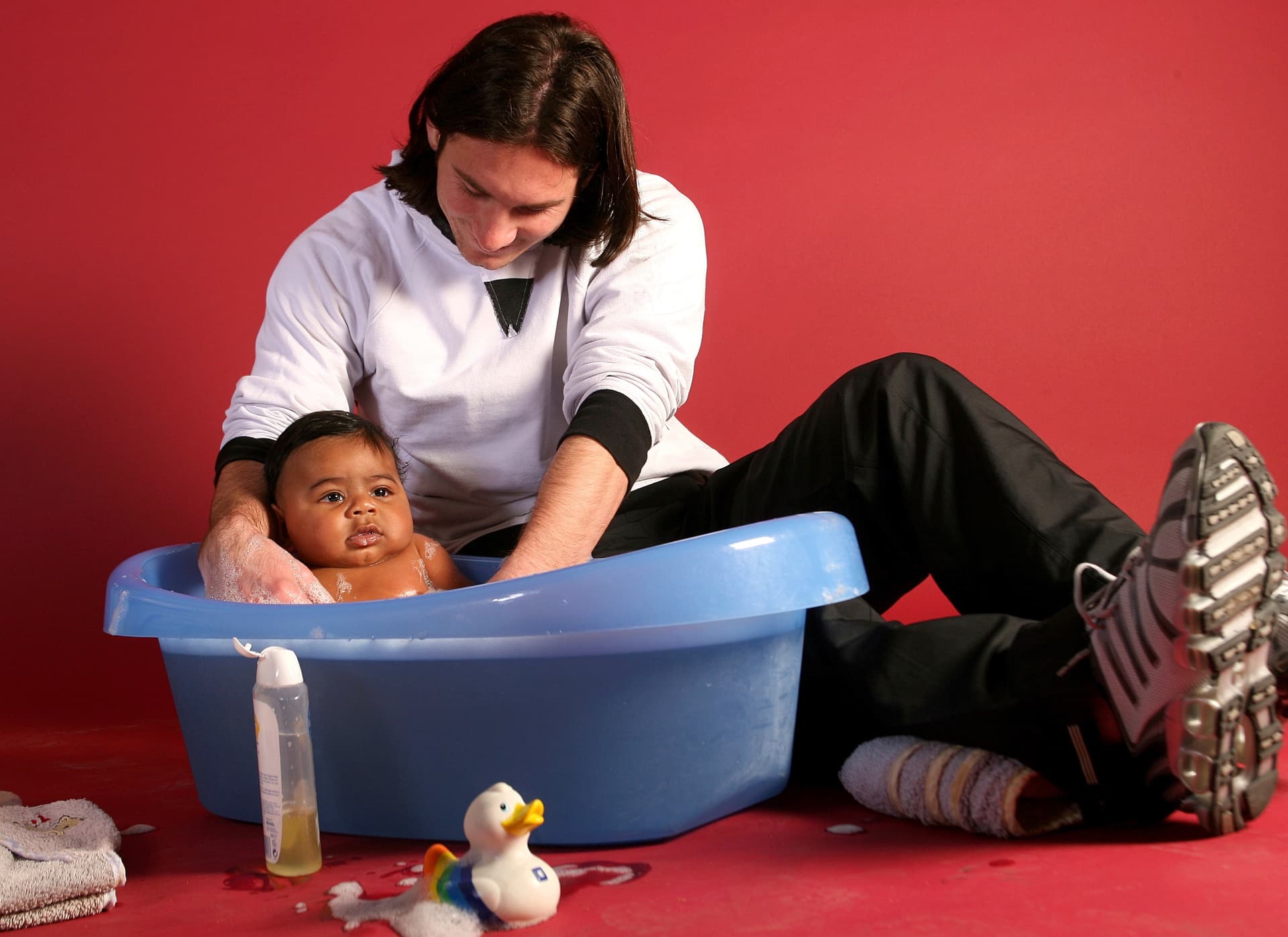Soccer star Lionel Messi, 20, helps to bathe a 6-month-old Lamine Yamal, during a photo session in the dressing room of the Camp Nou stadium in Barcelona, Spain, in September 2007. (Joan Monfort/AP Photo)