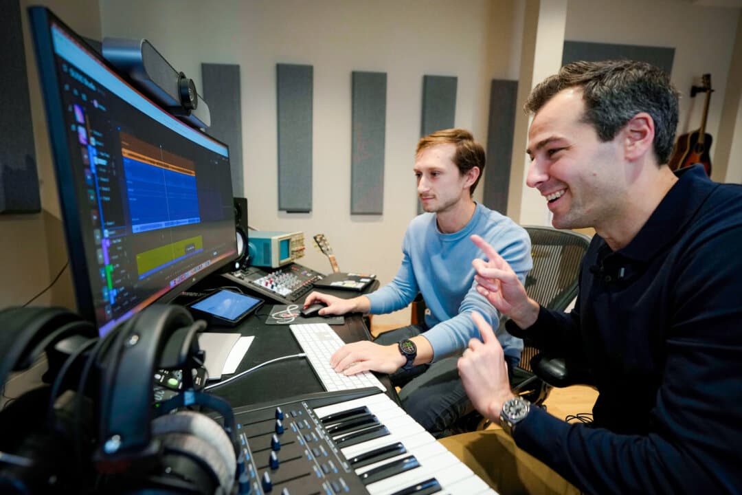 Research scientist Christian Steinmetz (L) and Mikey Shulman (R), one of the founders of AI music generator startup Suno, collaborate on creating a song, in Cambridge, Mass., on Jan. 13, 2026. (Robert F. Bukaty/AP Photo)