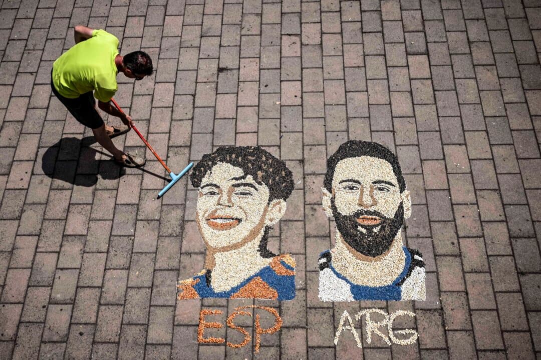 Kosovar artist Alkent Pozhegu puts the finishing touches to a mosaic on the ground, made with grain and seeds, depicting Argentina's forward #10 Lionel Messi (R) and Spain's forward #19 Lamine Yamal in the town of Gjakova, Kosovo, on July 16, 2026. (Armend Nimani/AFP via Getty Images)