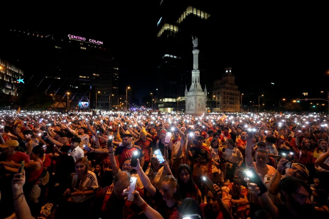 Spain's supporters turn on their phone flashlights as they watch the 2026 World Cup final match between Spain and Argentina displayed on giant screens underneath the Christopher Columbus statue on Plaza de Colón in Madrid, Spain, on July 19, 2026. (Paul Hanna/AFP via Getty Images)