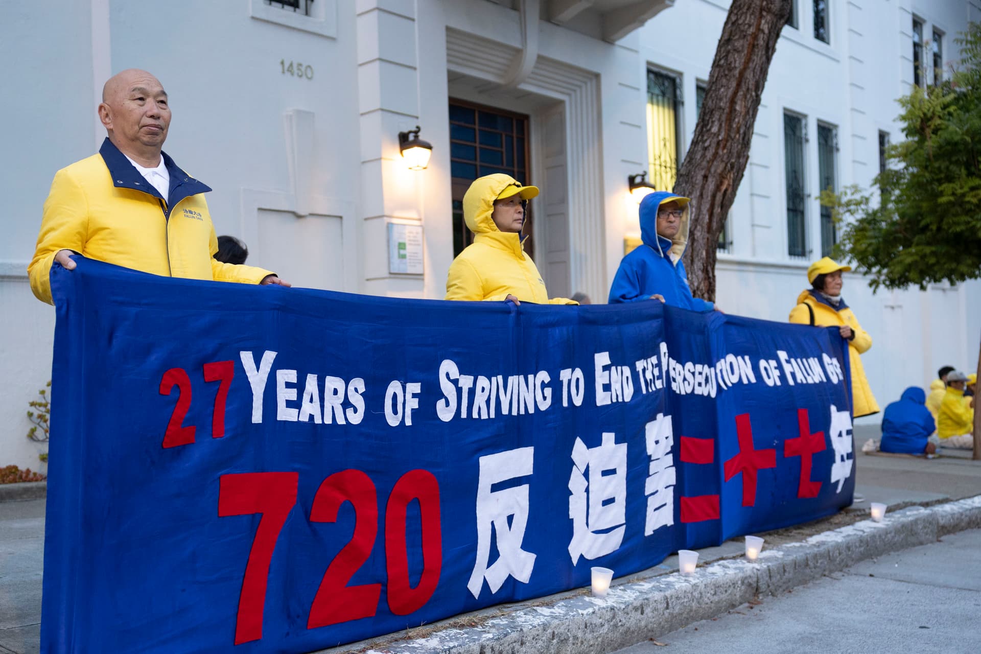 Chinese painter Wang Jianzhong (L) holds a banner in front of the Consulate General of China in San Francisco on July 19, 2026. (Lear Zhou/Epoch Times)