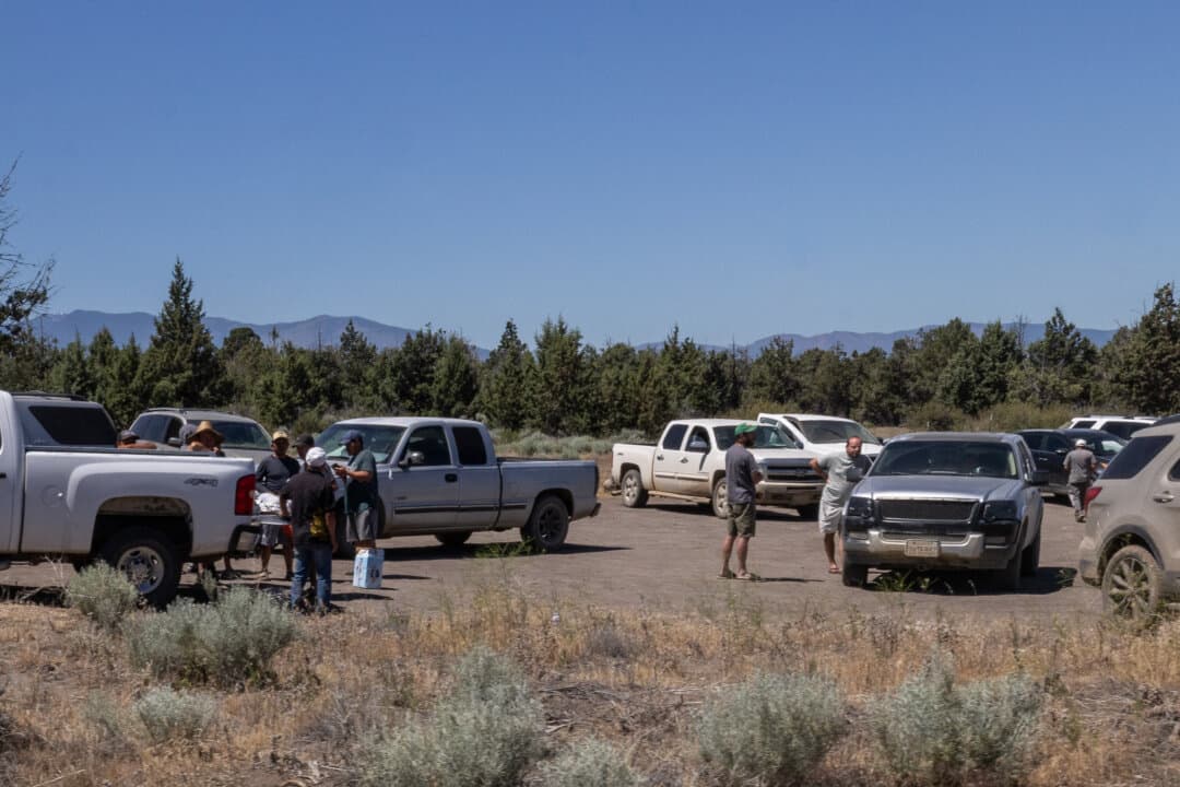 Men wait as police officers investigate illegal marijuana farms outside Montague, Calif., on June 4, 2026. (John Fredricks/The Epoch Times)