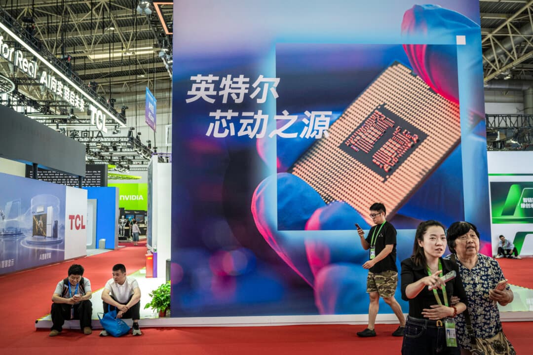 People near a billboard showing a semi-conductor chip, at the Chinese International Supply Chain Expo in Beijing on June 26, 2026. China is investing heavily in artificial intelligence and robotics, pouring billions of dollars into what the government sees as the country’s next economic engine. As part of the AI race, it is turning to second front tactics such as funding protests against data centers in the United States, analysts say. (Kevin Frayer/Getty Images)
