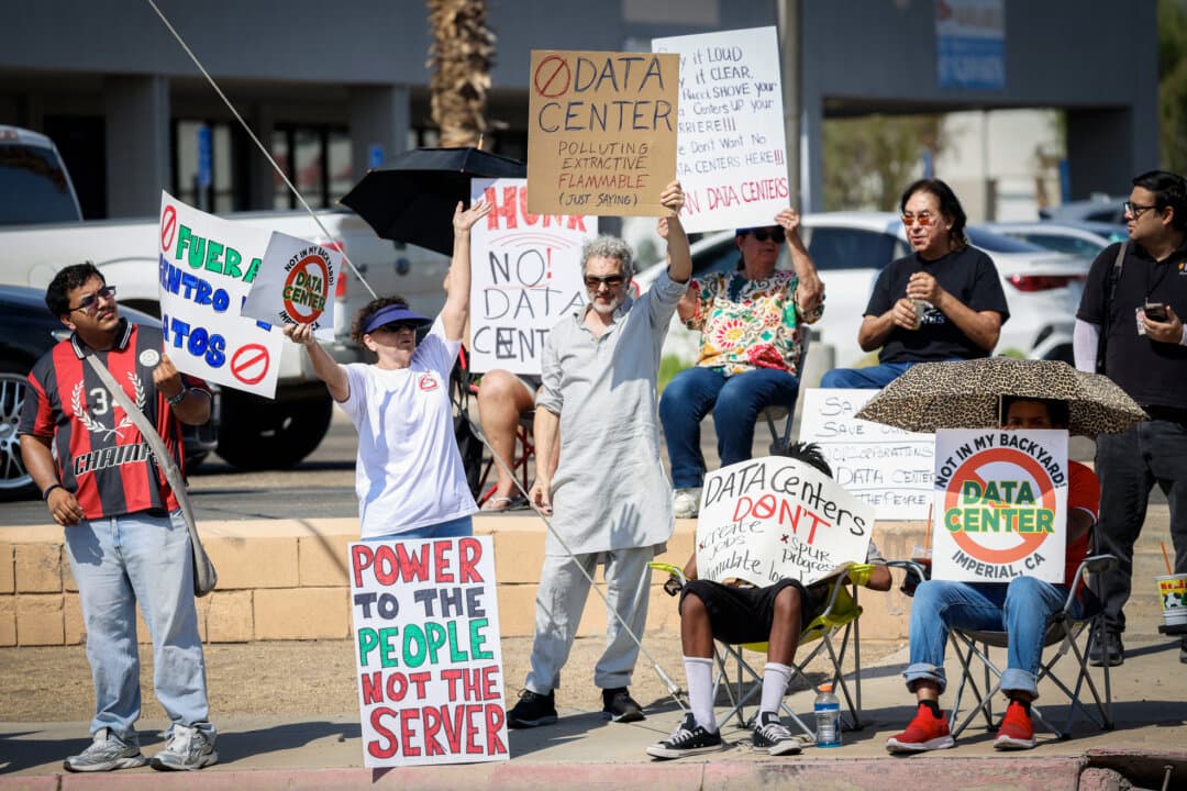 Demonstrators wave signs during a nationwide protest against AI data center expansion, in Imperial, Calif., on July 18, 2026. (Sandy Huffaker/AFP via Getty Images)
