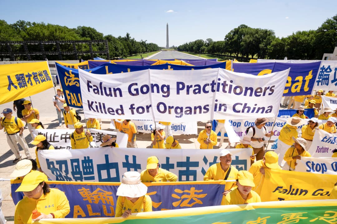 Falun Dafa practitioners hold banners at the Lincoln Memorial in Washington on July 23, 2026. (Samira Bouaou/The Epoch Times)