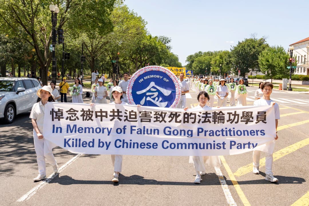 Falun Dafa practitioners hold a banner that reads “In memory of Falun Gong practitioners killed by Chinese Communist Party,” in Washington on July 23, 2026. (Samira Bouaou/The Epoch Times)