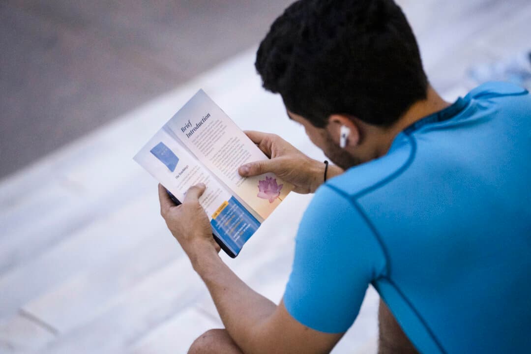A passerby reads a Falun Dafa flyer in Washington on July 23, 2026. (Madalina Kilroy/The Epoch Times)