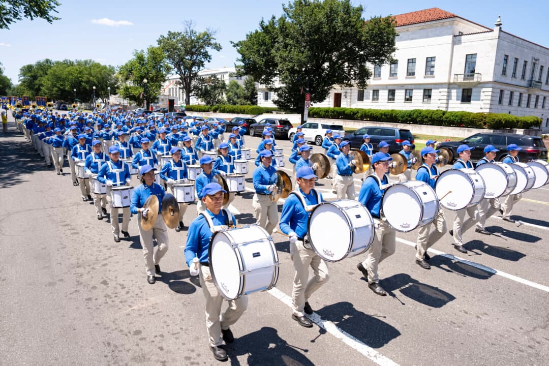 Tian Guo Marching Band, consisting of Falun Dafa practitioners, performs during the march in Washington on July 23, 2026. (Larry Dye/The Epoch Times)
