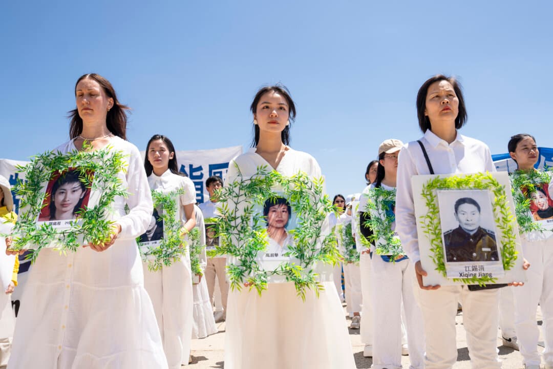 Falun Dafa practitioners hold photos of fellow practitioners who were persecuted to death by the Chinese Communist Party in China, at the Lincoln Memorial in Washington on July 23, 2026. (Madalina Kilroy/The Epoch Times)