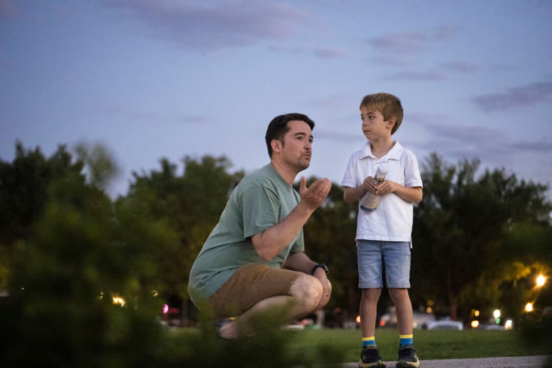 A family watches Falun Dafa practitioners meditate at the Lincoln Memorial in Washington on July 23, 2026. (Madalina Kilroy/The Epoch Times)