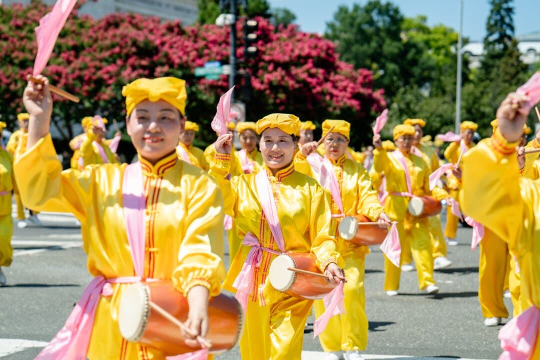 A waist drum team consisting of Falun Dafa practitioners performs during the march in Washington on July 23, 2026. (Samira Bouaou/The Epoch Times)