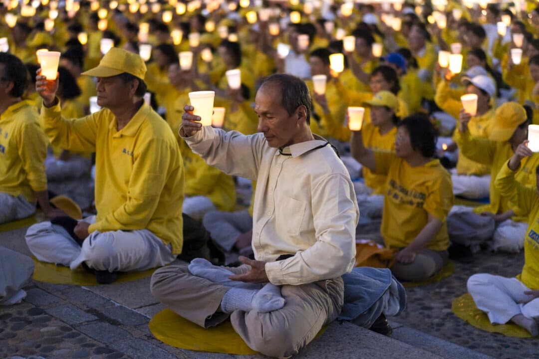 Falun Dafa practitioners hold a candlelight vigil at the Lincoln Memorial in Washington on July 23, 2026. (Madalina Kilroy/The Epoch Times)