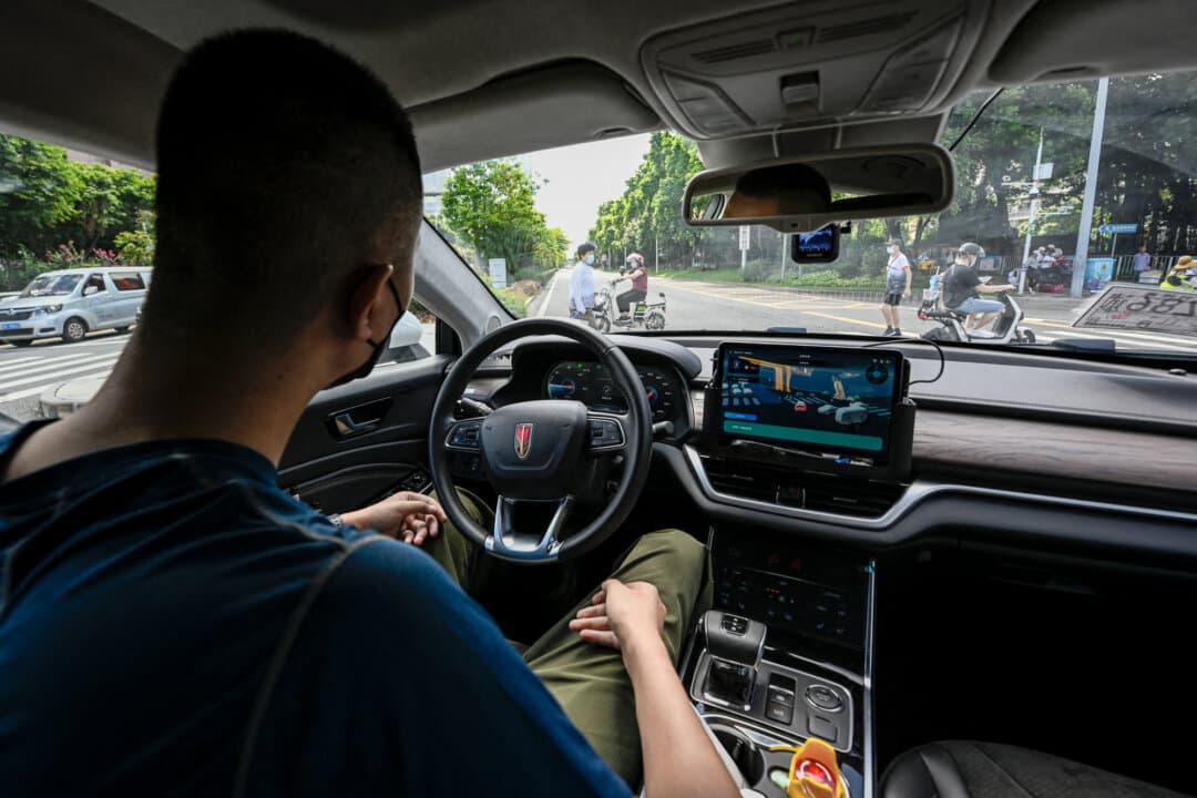 A robotaxi developed by Baidu Apollo stops as people cross a street in Shenzhen, in China's southern Guangdong Province, on July 10, 2022. Chinese-made vehicles include software from the Chinese technology company, which collects data from the vehicles and transmits them back to China. (Jade Gao/AFP via Getty Images)