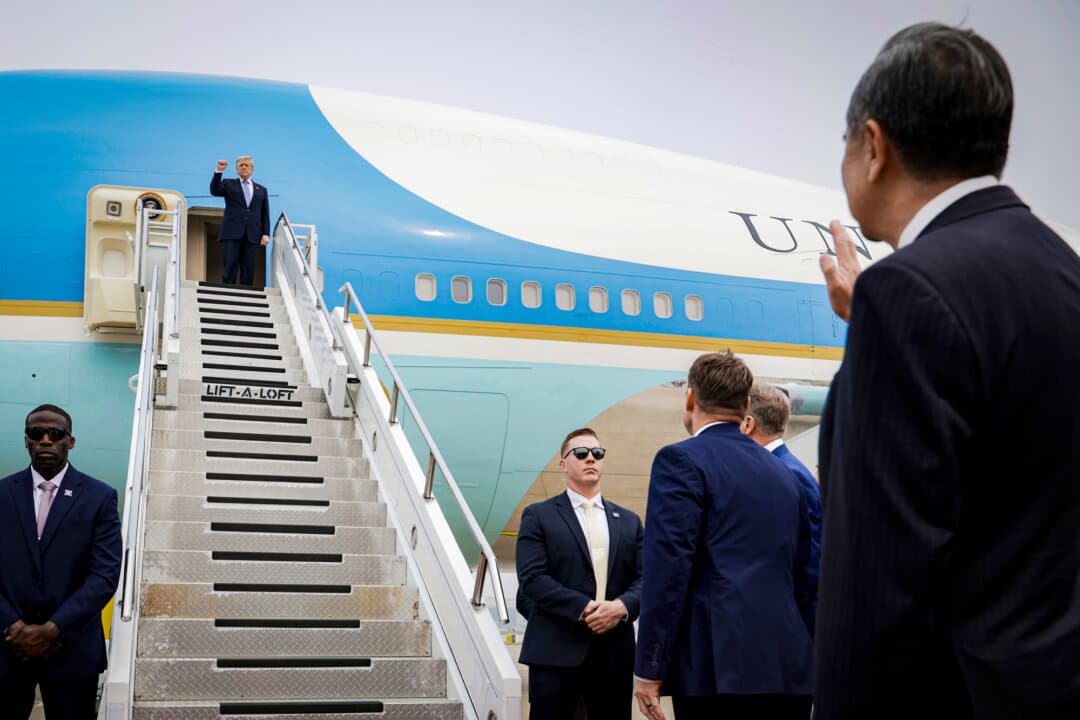 U.S. President Donald Trump gestures toward Chinese Foreign Minister Wang Yi as he prepares to board Air Force One at Beijing Capital International Airport in Beijing on May 15, 2026. China's foreign ministry has accused Washington of stretching the definition of national security to suppress Chinese companies. (Alex Wong/Getty Images)