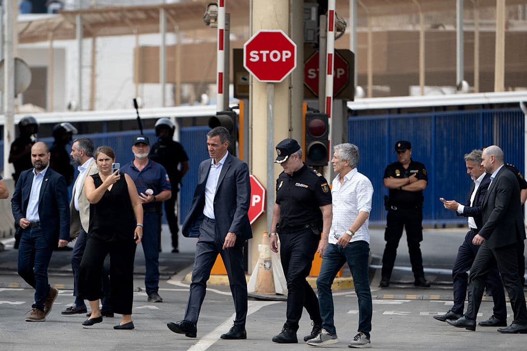 Spain's Prime Minister Pedro Sanchez (C) and Minister of Interior Fernando Grande Marlaska walk by the Tarajal border fence between Spain's north African enclave of Ceuta and Morocco during a visit amid one of the largest migrant crises on the country's border as thousands of migrants crossed overnight from Morocco on July 31, 2026. (Jorge Guerrero/AFP via Getty Images)