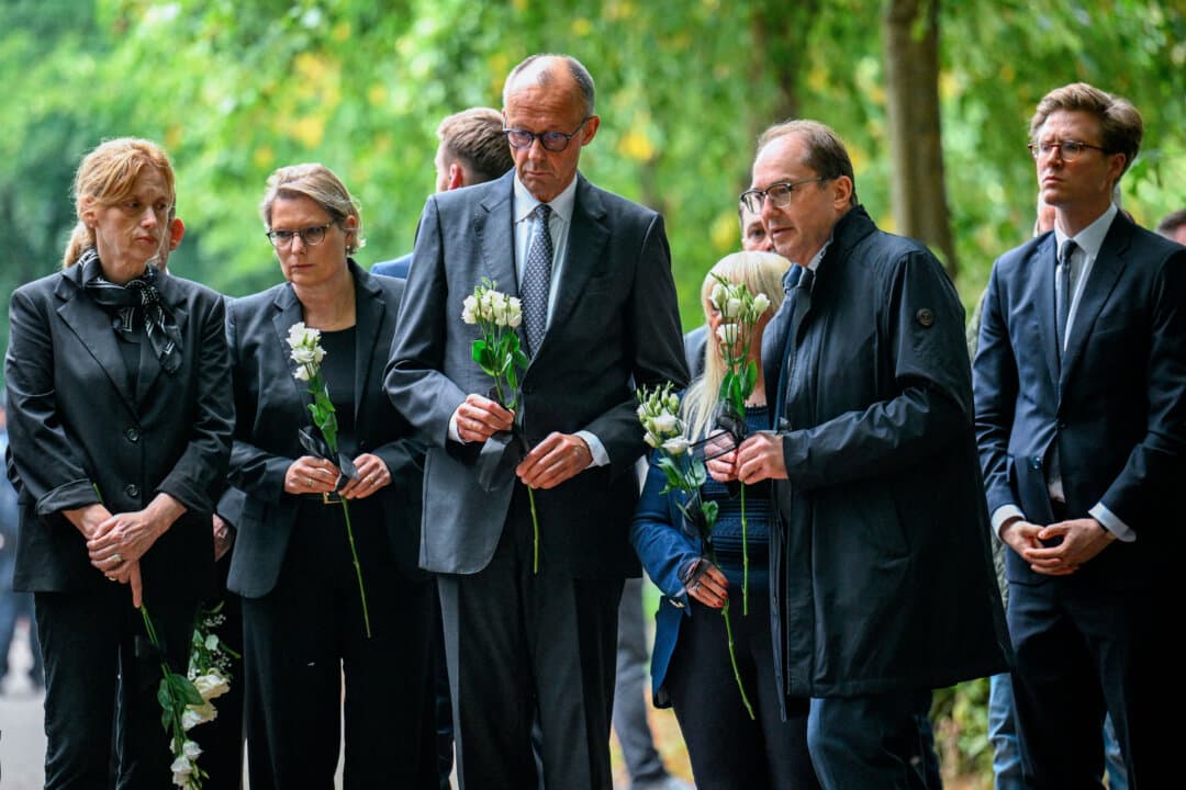 German Chancellor Friedrich Merz, German Interior Minister Alexander Dobrindt, Justice Minister Stefanie Hubig, and Family Minister Karin Prien prepare to lay flowers at the site in Berlin's Tiergarten park where a vehicle crashed into a crowd near the Christopher Street Day Pride parade in Berlin, on July 26, 2026. The crash left one woman dead and 29 others injured. (Annegret Hilse/POOL/AFP via Getty Images)