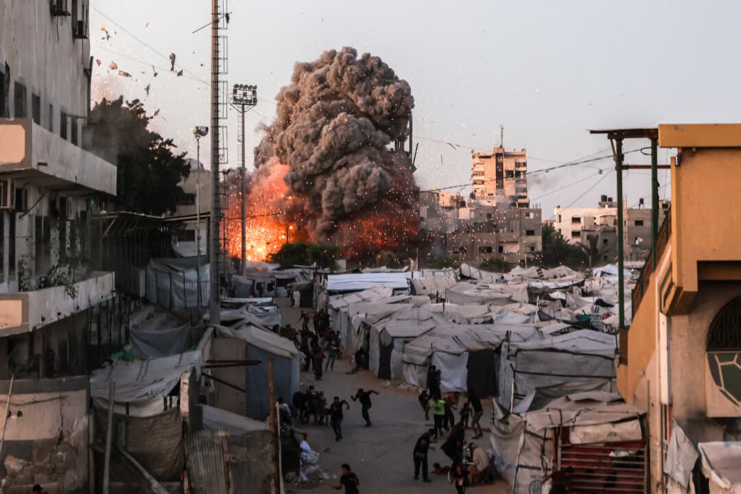 Palestinians run for cover as smoke and fire rise during an Israeli strike on the Al-Muttaqin Mosque in Gaza City, Gaza, on July 28, 2026. (Omar Al-Qattaa/AFP via Getty Images)