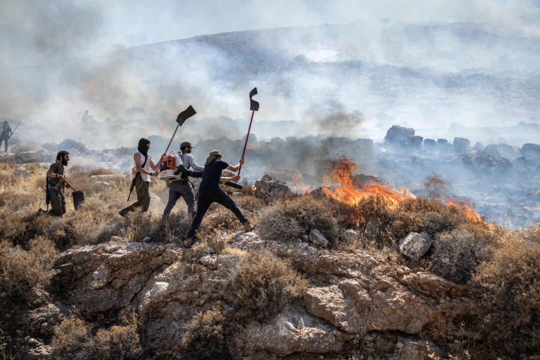 Israeli settlers try to extinguish a wildfire near the Ein Samiya spring in the West Bank on July 29, 2026. (Ilia Yefimovich/AFP via Getty Images)