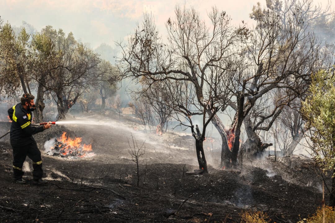 A firefighter sprays water to extinguish a fire in the town of Plomari on the Greek island of Lesbos, Greece, on July 29, 2026. (Manolis Lagoutaris/AFP via Getty Images)