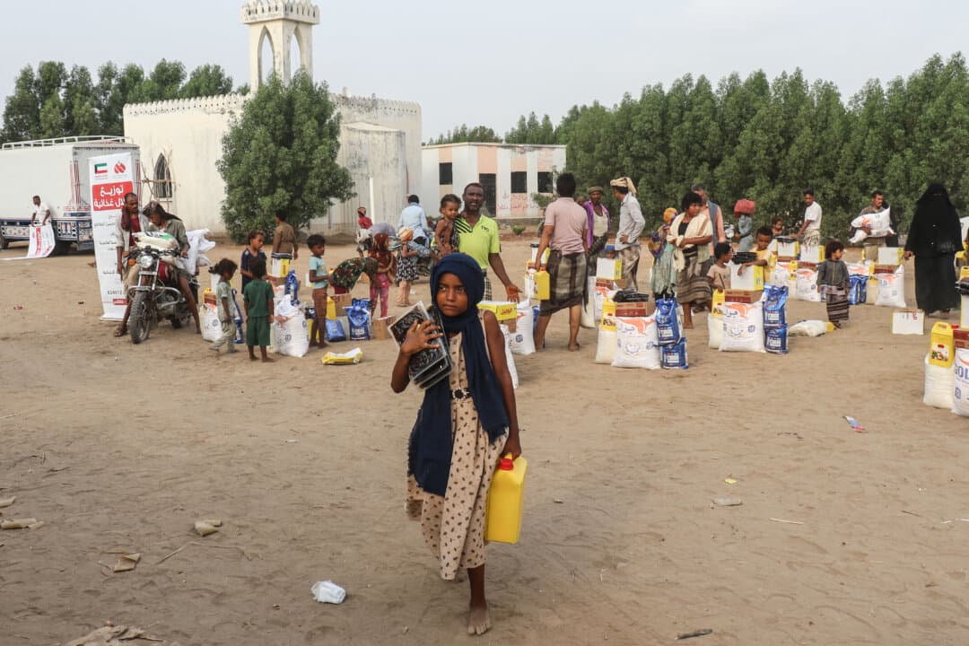 A girl carries a jerrycan as displaced people living in temporary shelters receive food aid, in Al-Khawkhah, Yemen, on July 30, 2026. (Khaled Ziad/AFP via Getty Images)
