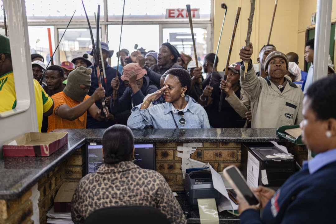 A woman reacts as protesters storm the Department of Home Affairs offices during a demonstration calling for the removal of illegal immigrants, in Alexandra township, South Africa, on July 30, 2026. The protests come amid mounting pressure on the government over migration, with some activists and groups blaming illegal immigrants for crime, unemployment, and strain on public services. (Emmanuel Croset/AFP via Getty Images)