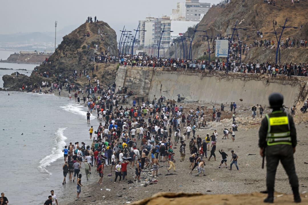 Illegal immigrants gather along the fence at the site of clashes near Fnideq on the Morocco–Spain border, in Fnideq, Morocco, on July 31, 2026. Thousands of illegal immigrants crossed overnight from Morocco into Spain's North African enclave of Ceuta, according to a police source, with 18 people reported dead while attempting to reach the enclave. (Abdel Majid Bziouat/AFP via Getty Images)