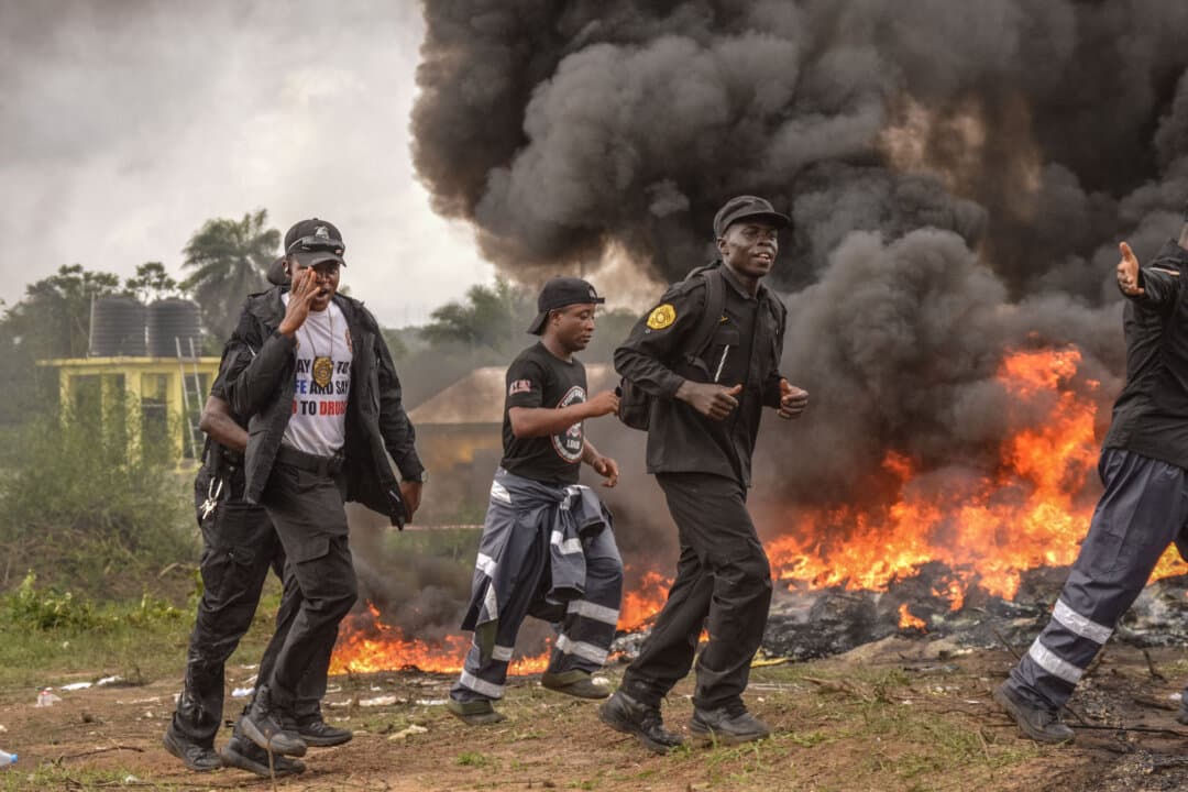 Members of Liberia Joint Security, an inter-agency task force coordinated by the Ministry of Justice and National Security Council, celebrate the burning of 4,208.6 kilograms (9278 pounds) of cocaine during a public display, in Careysburg, Liberia, on July 30, 2026. Liberian authorities announced the seizure of nearly four tons of cocaine valued at $317 million in a major drug bust that led to the arrest of two foreign nationals. (Matthew Jacobs/AFP via Getty Images)