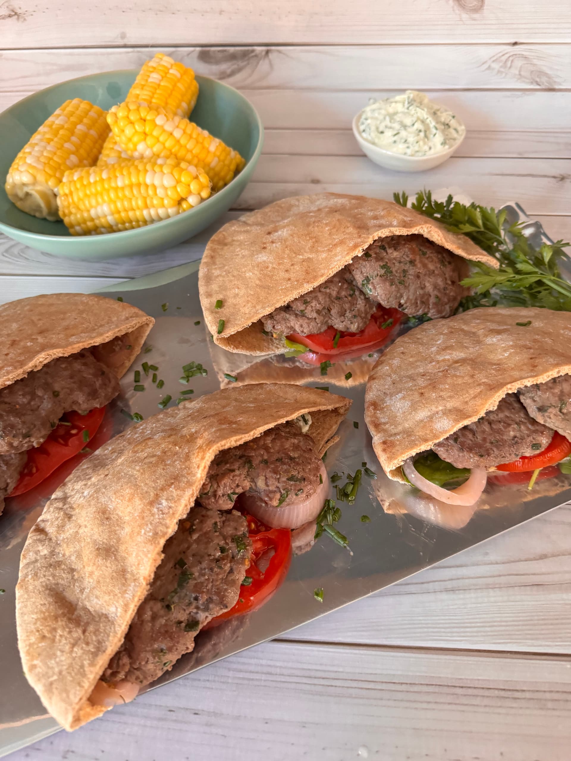 Enjoy smashed lamb burgers tucked into warm pita, served with sweet corn and creamy cucumber whipped feta. (JeanMarie Brownson/TCA)